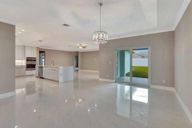 empty room featuring crown molding, marble finish floor, a sink, and baseboards