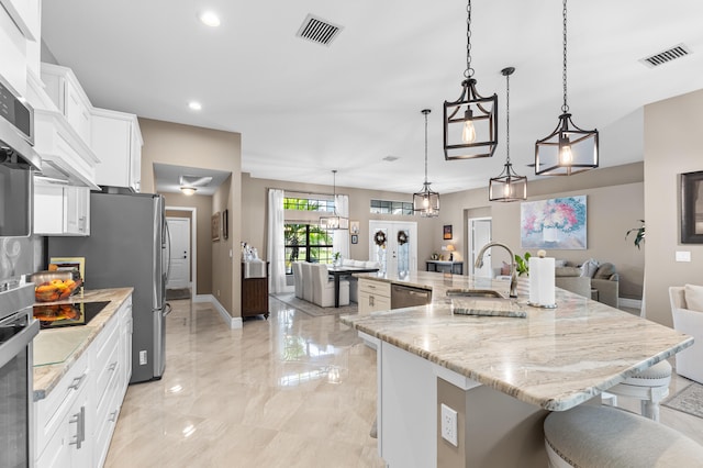 kitchen featuring open floor plan, hanging light fixtures, a large island, and visible vents