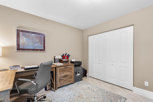 office featuring a textured ceiling and baseboards