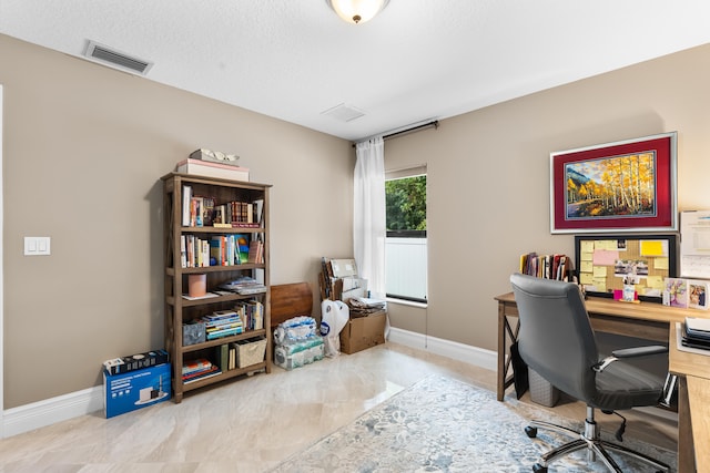 office with baseboards, visible vents, and a textured ceiling