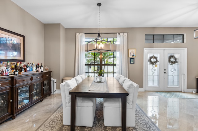 dining area featuring baseboards, marble finish floor, french doors, and an inviting chandelier