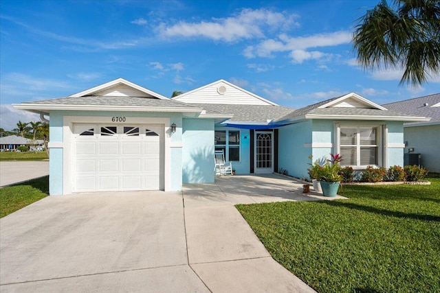 ranch-style house with an attached garage, a shingled roof, driveway, stucco siding, and a front lawn