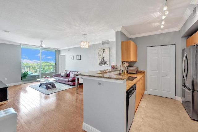 kitchen with open floor plan, decorative light fixtures, a peninsula, stainless steel appliances, and a sink