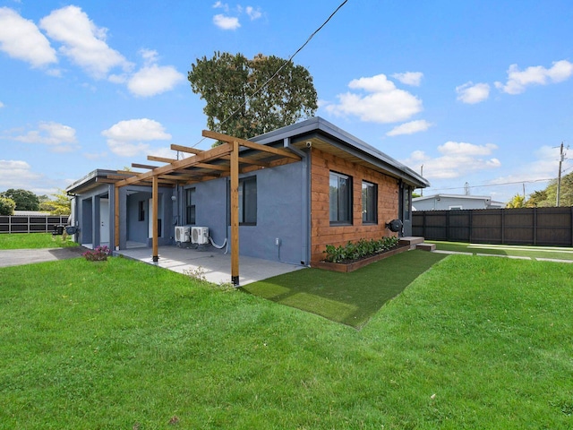 back of house with a patio, a lawn, fence, and stucco siding