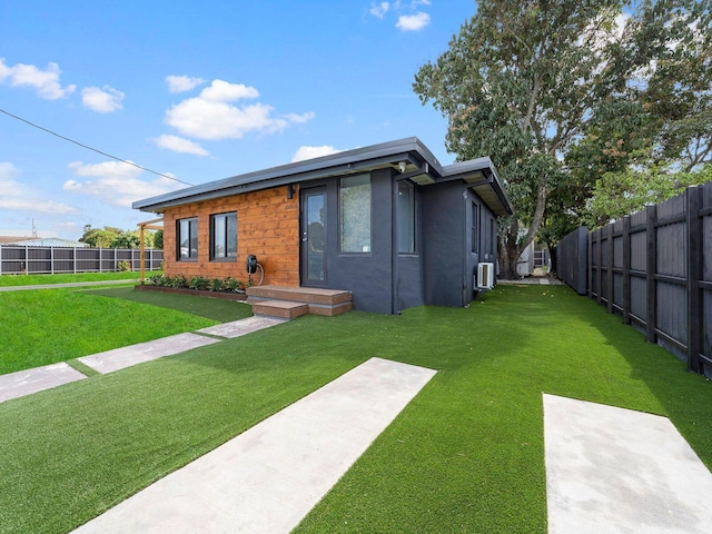 view of front of home with a fenced backyard, a front lawn, and stucco siding