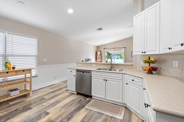 kitchen with a peninsula, a sink, white cabinetry, light countertops, and dishwasher