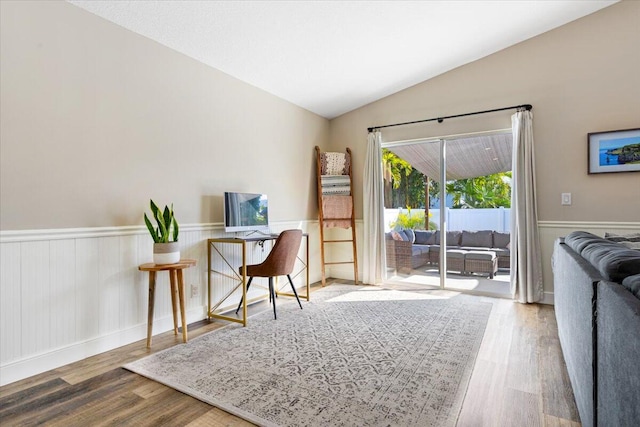 office with lofted ceiling, a wainscoted wall, and wood finished floors