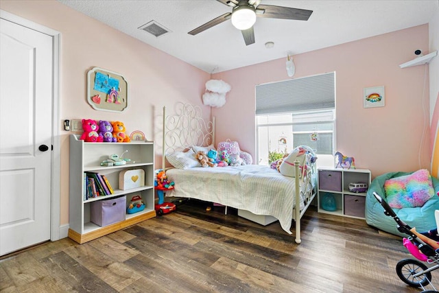 bedroom featuring visible vents, ceiling fan, and wood finished floors