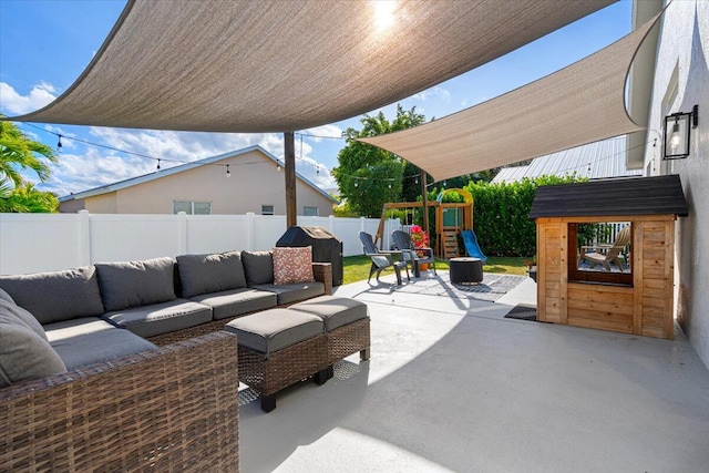 view of patio / terrace featuring a fenced backyard, an outdoor living space, and a playground