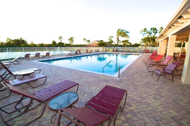 pool with a patio area and fence