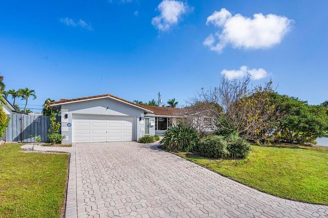 single story home with a garage, a front lawn, decorative driveway, and stucco siding