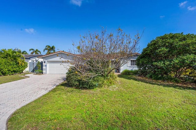 view of front of property with a garage, a front lawn, and decorative driveway