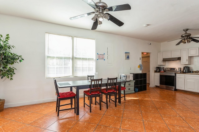 dining space with ceiling fan, light tile patterned flooring, and baseboards