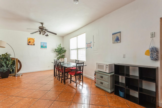 dining room with ceiling fan, baseboards, and tile patterned floors