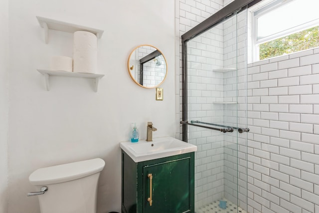 bathroom with a stall shower, vanity, and toilet