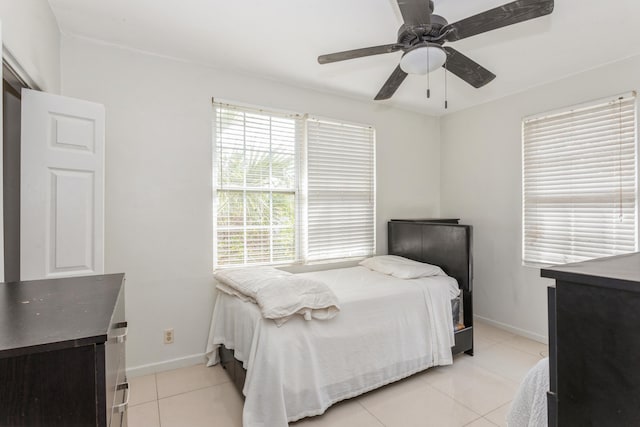 bedroom with light tile patterned floors, ceiling fan, and baseboards