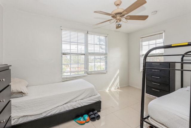 bedroom featuring light tile patterned floors, multiple windows, and a ceiling fan