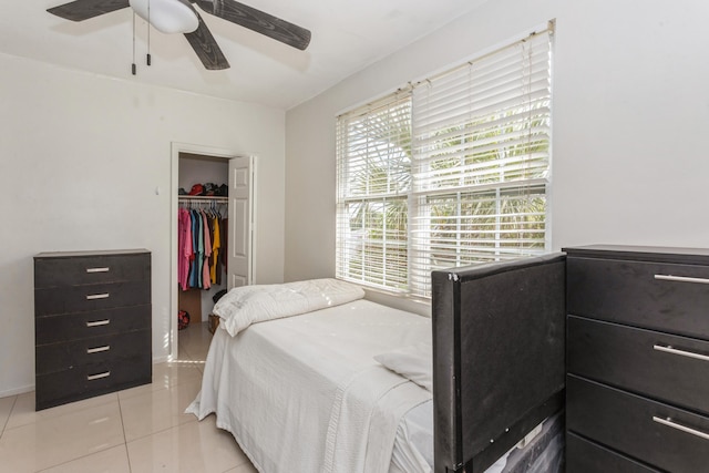 bedroom with ceiling fan, light tile patterned flooring, baseboards, a closet, and a walk in closet