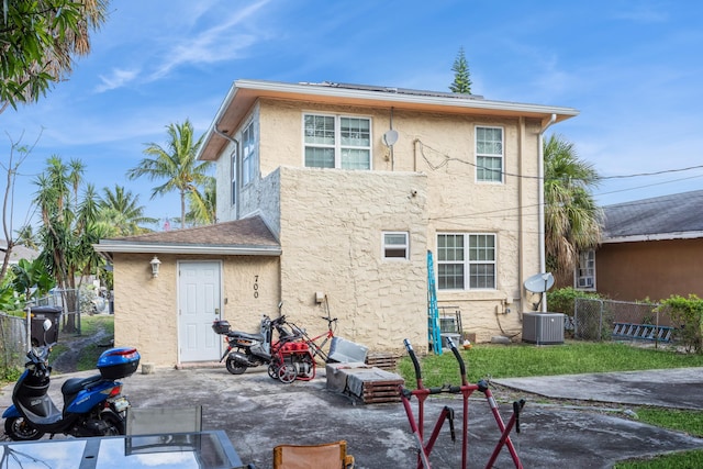 back of house featuring a patio area, cooling unit, fence, and stucco siding