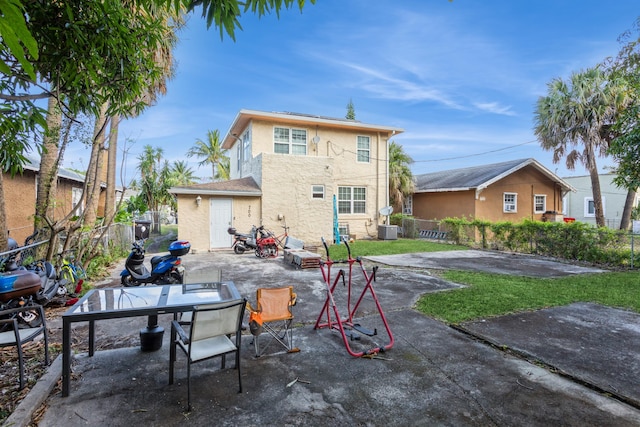 rear view of property with stucco siding, fence, and a patio