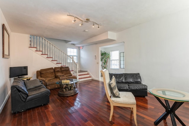 living area featuring baseboards, stairway, and wood finished floors