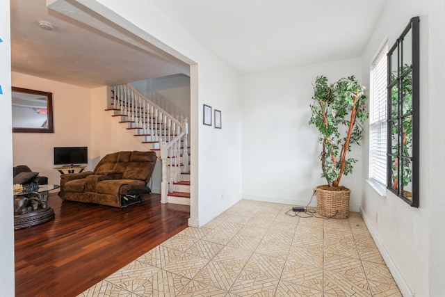 interior space featuring light wood finished floors, baseboards, and stairway