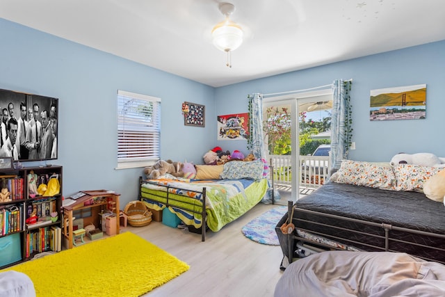 bedroom with access to exterior and wood finished floors