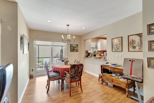 dining space featuring a notable chandelier, light wood-style flooring, and baseboards