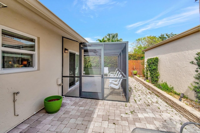 view of patio / terrace featuring a lanai and fence