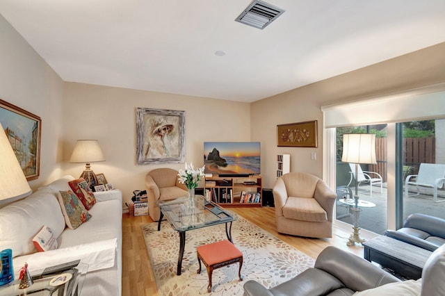 living area featuring light wood-style flooring and visible vents