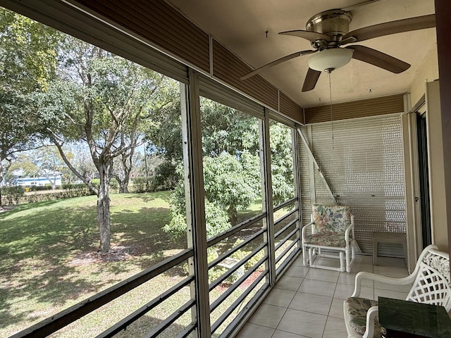 unfurnished sunroom with ceiling fan