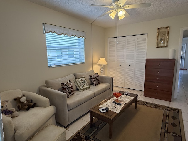 living area featuring a textured ceiling, ceiling fan, and light tile patterned floors
