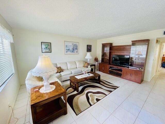 living area featuring a textured ceiling and light tile patterned floors