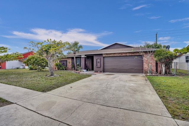 single story home featuring a garage, concrete driveway, brick siding, and a front lawn