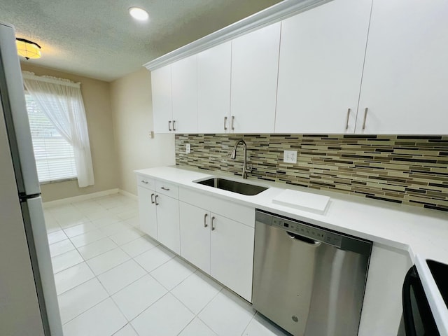 kitchen featuring dishwasher, light countertops, a sink, and white cabinetry