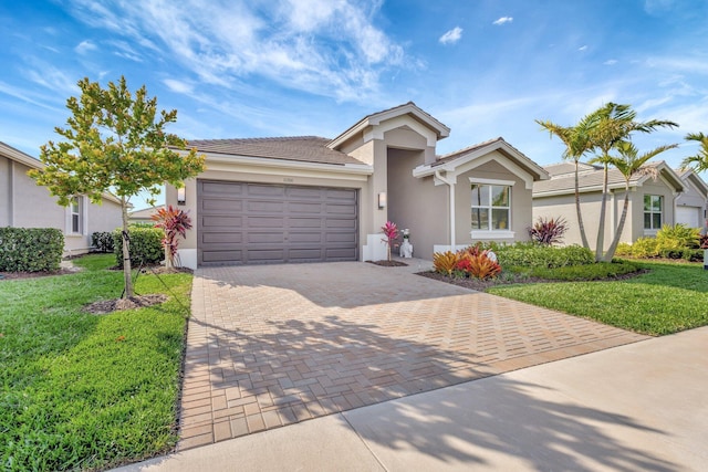 ranch-style home featuring a garage, decorative driveway, a front yard, and stucco siding