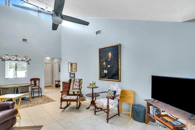 living area featuring a ceiling fan, visible vents, a textured ceiling, and light tile patterned flooring