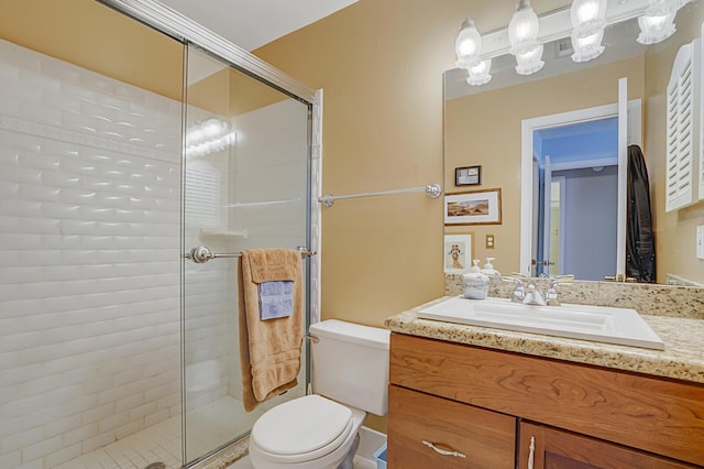 full bathroom with toilet, a stall shower, visible vents, and vanity