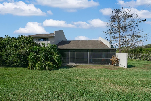 rear view of house with a sunroom and a yard