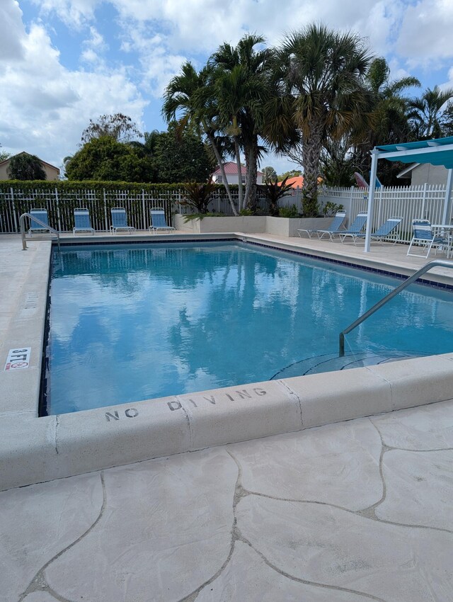 community pool featuring a patio area and fence