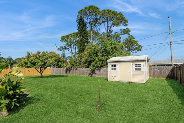 view of yard with an outbuilding, a storage unit, and a fenced backyard