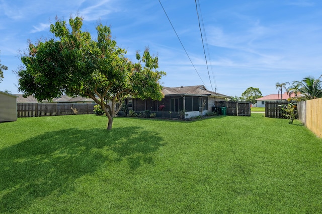 view of yard featuring a fenced backyard and a sunroom