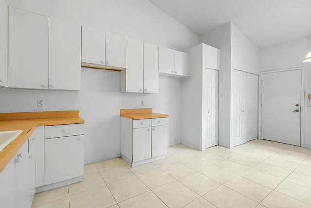 kitchen with light tile patterned flooring, light countertops, and white cabinetry