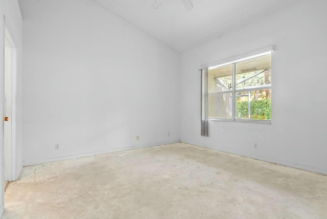 unfurnished room with unfinished concrete floors and vaulted ceiling