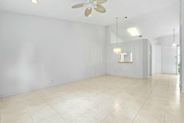 spare room with ceiling fan with notable chandelier, light tile patterned flooring, lofted ceiling, and recessed lighting