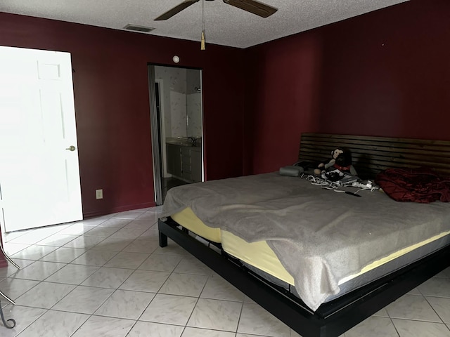 bedroom featuring light tile patterned floors, a ceiling fan, visible vents, and a textured ceiling