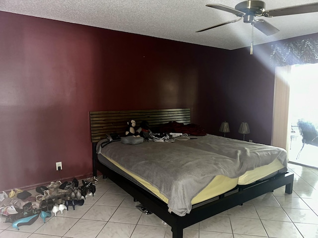 bedroom featuring light tile patterned floors, ceiling fan, and a textured ceiling