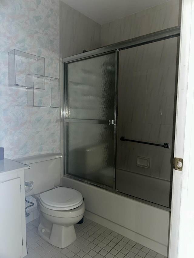 full bathroom featuring wallpapered walls, toilet, shower / bath combination with glass door, tile patterned flooring, and vanity