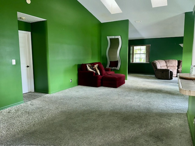 living area featuring carpet floors, a skylight, high vaulted ceiling, and visible vents