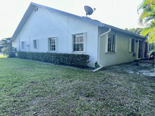 view of property exterior with a yard and stucco siding